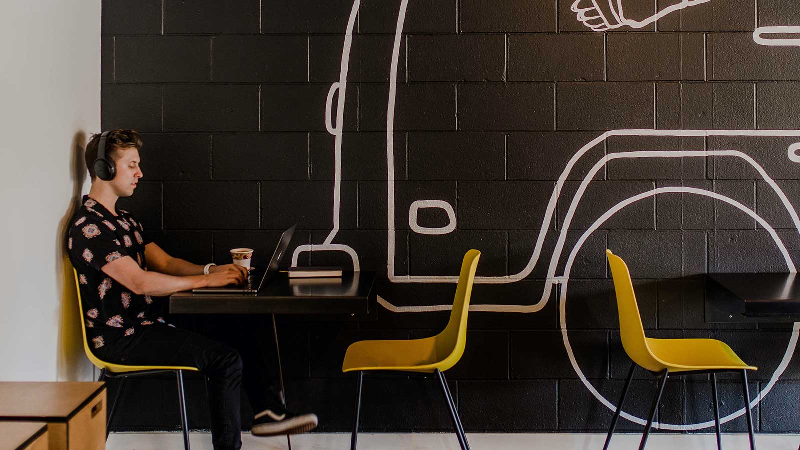 Man på café med hörlurar.